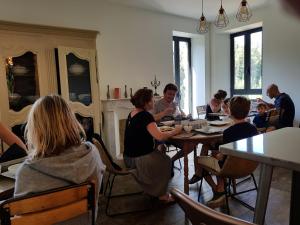 un grupo de personas sentadas en mesas en una habitación en A Bella Scusa, en Bastelica