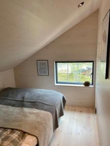 a bedroom with a bed and a window in a attic at Ny hytte i Malangen in Nordby