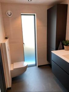 Łazienka z toaletą i przesuwnymi szklanymi drzwiami w obiekcie Ny hytte i Malangen w mieście Nordby