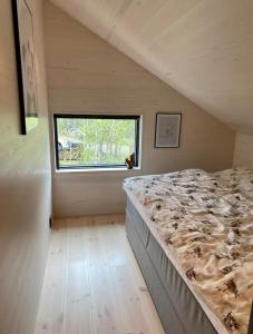 een groot bed in een kamer met een raam bij Ny hytte i Malangen in Nordby +35 foto's
