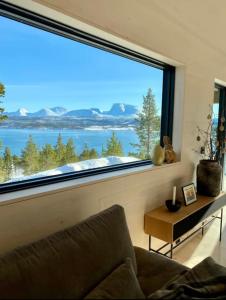 a living room with a large window with a view at Ny hytte i Malangen in Nordby