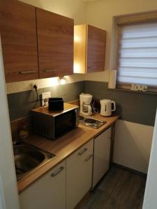 a kitchen with a sink and a microwave on a counter at FEWO Kliff Watt Nr.4 in Cuxhaven