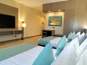 ein Hotelzimmer mit 2 Betten und einem Flachbild-TV in der Unterkunft WATERWORLD HOTEL in Mandaue City