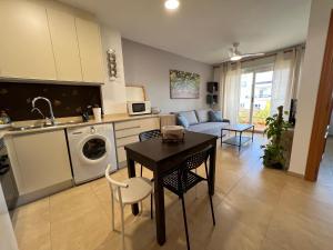 een keuken en een woonkamer met een tafel en een bank bij Apartamento Segrelles 22 in Canet de Berenguer