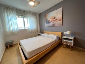 een slaapkamer met een groot bed en een raam bij Apartamento Segrelles 22 in Canet de Berenguer