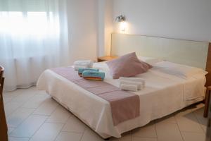 Sikelika Residence Sul Mare في سكولييتي: غرفة نوم عليها سرير وعلبتين