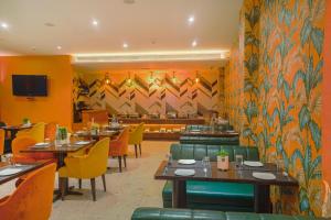 een restaurant met tafels en stoelen en een muurschildering bij Pax The Mustard Inn in Amritsar