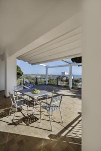 スコリッティにあるSikelika Residence Sul Mareのパティオ(日よけの下にテーブルと椅子付)