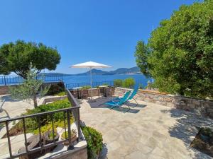 a patio with a table and an umbrella at Apartments Mitrovići Miločer in Sveti Stefan