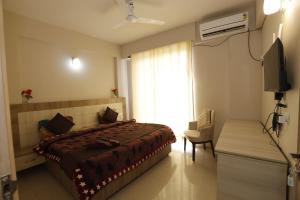 a bedroom with a bed and a tv and a window at The Grand View Studio in Vrindāvan