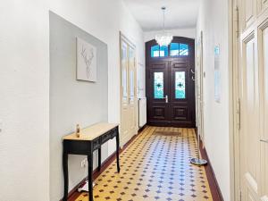 un pasillo con una mesa y una puerta en Ferienwohnung Villa Nieske - Jugendstil Denkmal, free WLAN & Parken, Self Check-In, Smart-TV, en Herzberg