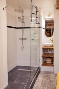 a bathroom with a glass shower with a sink at Le Chapeau Rouge - Centre Historique - Corum in Montpellier