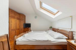 a bedroom with a large white bed with a skylight at Bed and Breakfast Mili Vrh in Kamnik