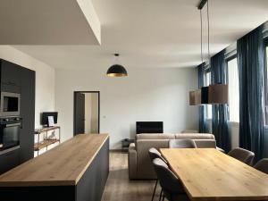 Appartement de charme + parking centre-ville Arras في أراس: غرفة معيشة مع طاولة وأريكة
