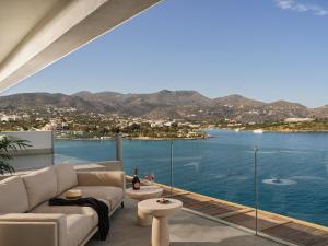 a living room with a view of the water at NIKO Seaside Resort MGallery in Agios Nikolaos