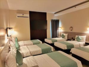 ein Hotelzimmer mit 3 Betten und einem TV in der Unterkunft WATERWORLD HOTEL in Mandaue City