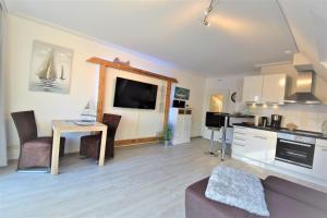 a living room with a kitchen and a table with a couch at An de Warft Schatz am Deich in Büsum