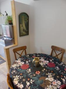 Maison de village au calme axe Annecy - Genève في فييِ لو بولو: طاولة غرفة الطعام عليها نمط زهرة