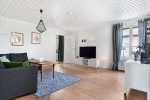 - un salon avec un canapé et une télévision dans l'établissement Guestly Homes - 4BR Charming Apartment, à Roknäs