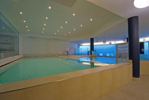 een zwembad in een groot gebouw met een zwembad bij Hotel Royal in Riva del Garda