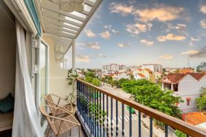a balcony with a view of a city at Amina Lantana Hoi An Hotel & Spa in Hoi An