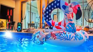 a swimming pool with an american flag themed float in the water at NKR Poolvilla in Ban Don