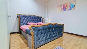 un letto blu con cuscini rosa in una stanza di NKR Poolvilla a Ban Don