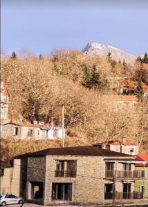 a building with a car parked in front of a mountain at The Black Chestnut in Áyios Nikólaos