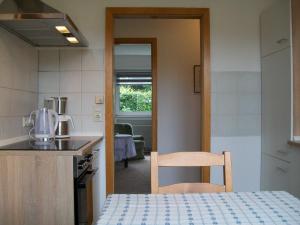 a kitchen with a table and a chair in a room at Haus Holste in Hambergen