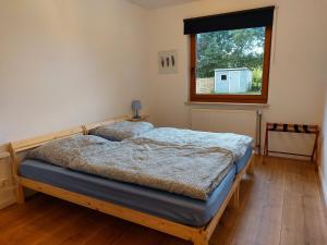 a bedroom with a bed and a window at Ferienwohnung am Wald 