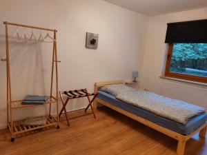 a bedroom with a bed and a wooden floor at Ferienwohnung am Wald 