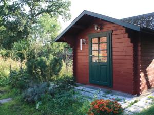 un pequeño cobertizo rojo con una puerta verde en Herzfeldhof Worpswede, en Worpswede