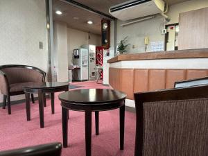 un restaurante con 2 mesas y sillas y una barra en Business Hotel Ishimura, en Mibu