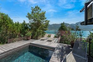 uma casa com uma piscina com vista para a água em Lac d'Annecy villa d'exception avec accès au lac : Villa Hollywood em Sévrier