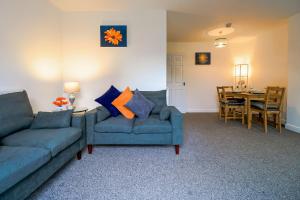ein Wohnzimmer mit 2 Sofas und einem Esszimmer in der Unterkunft Admirals House - Cosy house in quiet cul-de-sac in Gaywood