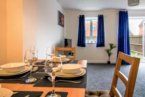 a dining room with a table with wine glasses at Admirals House - Cosy house in quiet cul-de-sac in Gaywood