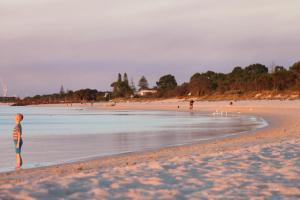 un joven parado en una playa de arena en Busselton Beachside, en Busselton