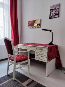 a desk with a lamp and a chair in a room at Julia Apartment in Budapest