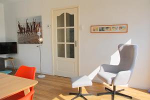 a room with a table and two chairs and a door at Previnaireweg 32 in Callantsoog