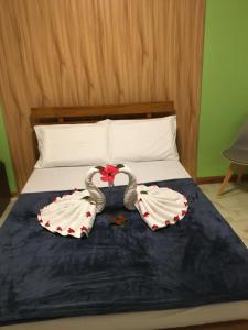 Zwei Schwänze, die so aussehen, als wären sie auf einem Bett. in der Unterkunft GBU Loboc River Guesthouse in Loboc