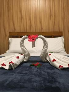 Dos torres se parecen a cisnes en una cama en GBU Loboc River Guesthouse en Loboc