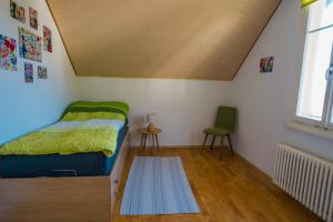1 dormitorio pequeño con 1 cama y 1 silla en Naturoase Säntisblick-Auszeit am Wald und Bach en Kradolf