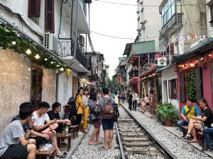 a group of people standing on a street with train tracks at Amazing View, Natural View, 3' To Hoan Kiem Lake, Free Wifi, Netflix, 2 Beds, 1 Toilet-2 Showers in Hanoi