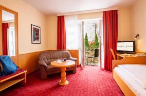 une chambre d'hôtel avec un lit et une chaise dans l'établissement Hotel Bergfried & Schönblick, à Bad Reichenhall