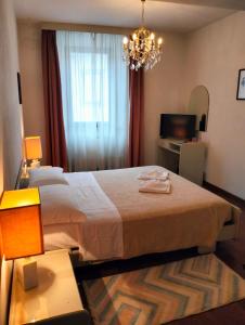 a bedroom with a large bed and a chandelier at "FUERTE " Affittacamere in Montevettolini