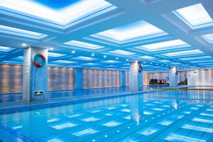 an indoor swimming pool with blue ceilings and a swimming pool at Plaza Hotel Yuyao in Yuyao