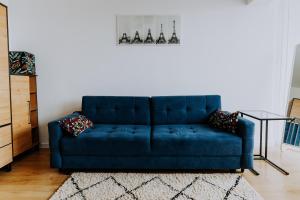 um sofá azul sentado numa sala de estar em Komfortowy Apartament W Centrum Wrocławia em Breslávia