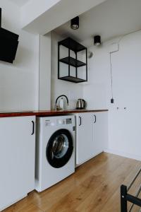 uma cozinha com uma máquina de lavar roupa e um lavatório em Komfortowy Apartament W Centrum Wrocławia em Breslávia