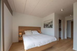 Appartement UBAC في Rovagny: غرفة نوم بسرير كبير مع شراشف بيضاء