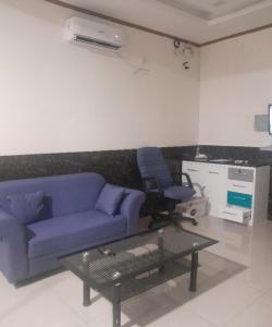 uma sala de estar com um sofá azul e uma cadeira em SPOT ON 93851 Fermansio Homestay 1 em Medan